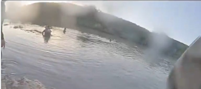 Officers negotiate with a human smuggler who jumped into the Rio Grande with a baby while attempting to avoid arrest near Laredo on December 19, 2025