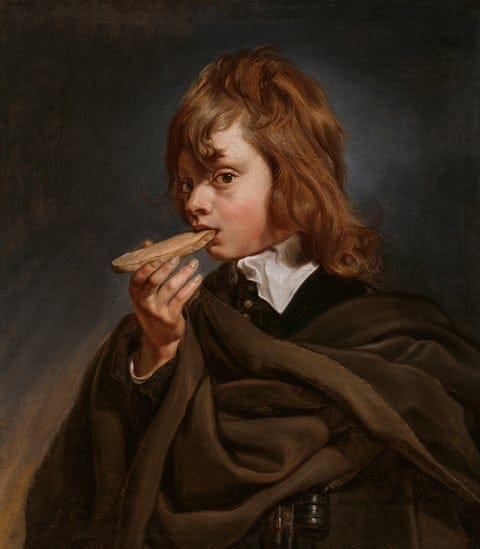 A boy looks at the painter as he bites a piece of bread