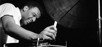 This may contain: a black and white photo of a man playing drums