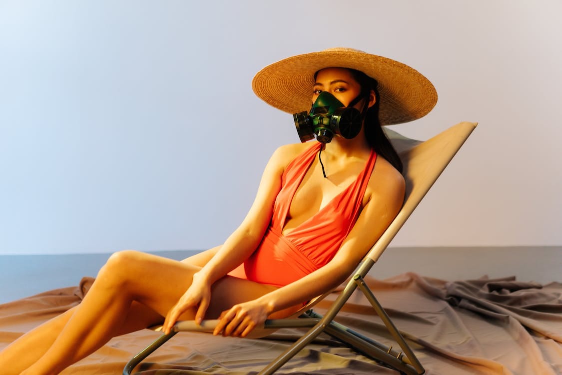 Free Woman Wearing Respirator Sitting on a Chair Stock Photo