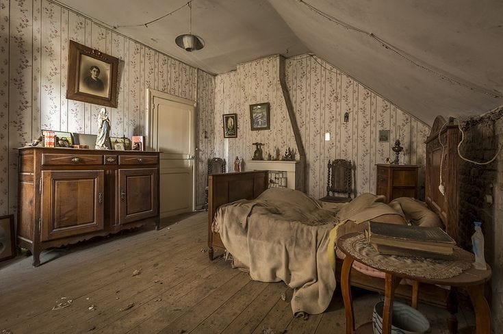 This may contain: an old fashioned bedroom with wooden floors and walls
