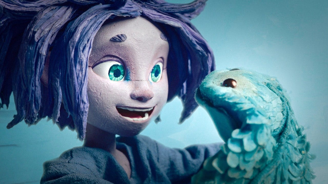 Stop-motion animated character with blue hair and bright turquoise eyes holding a teal six-armed creature in a co-op video game — handmade stop-motion craft demonstrating character design and tactile animation detail