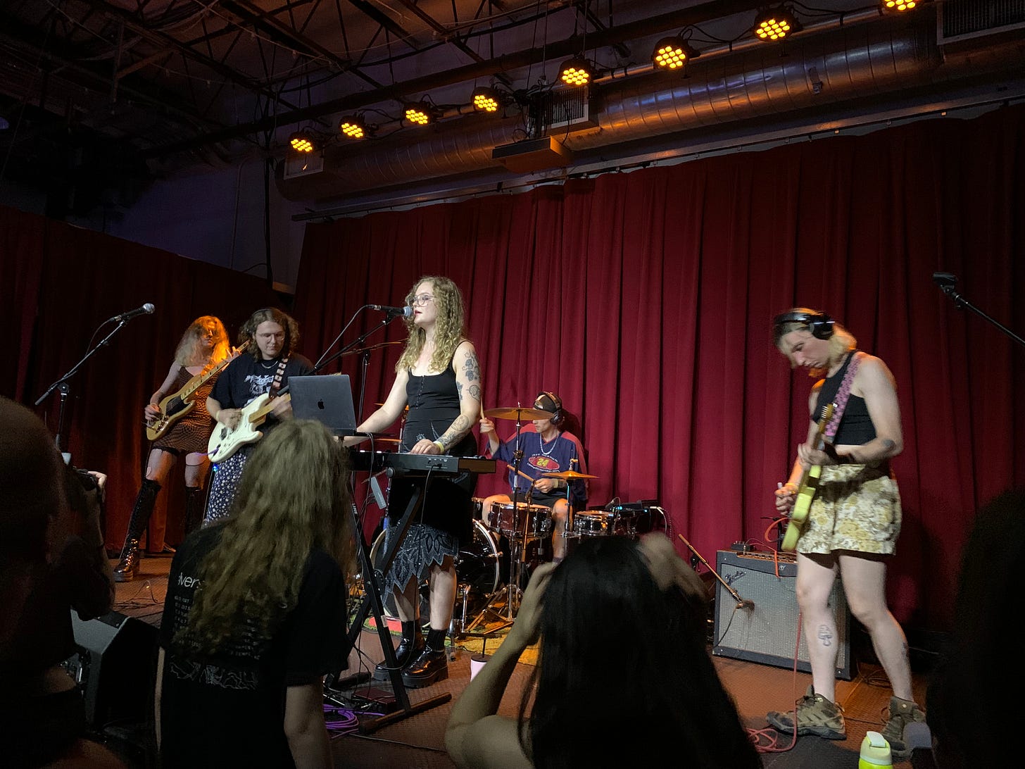 Pinky Lemon performing at Songbyrd Music House. Everyone in this band has really luxurious, long, often curly hair.