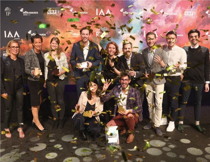 a group of people standing in front of a crowd posing for the camera
