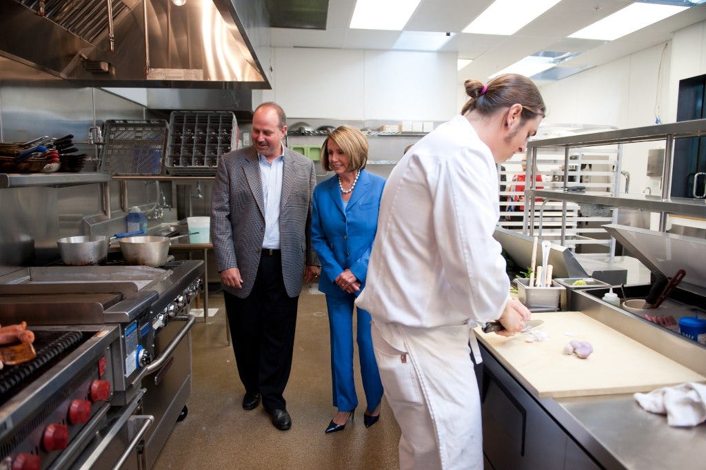 Photo: Nancy Pelosi from San Francisco, CA / Wikimedia Commons (CC BY 2.0) September 13, 2010 ~ Congresswoman Pelosi tours the kitchen of The Culinary Edge in San Francisco, which received a loan from the U.S. Small Business Administration, with founder Aaron Noveshen.