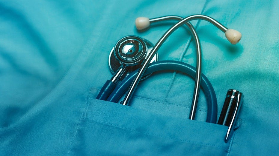 Stethoscope and pen in doctor robe pocket.