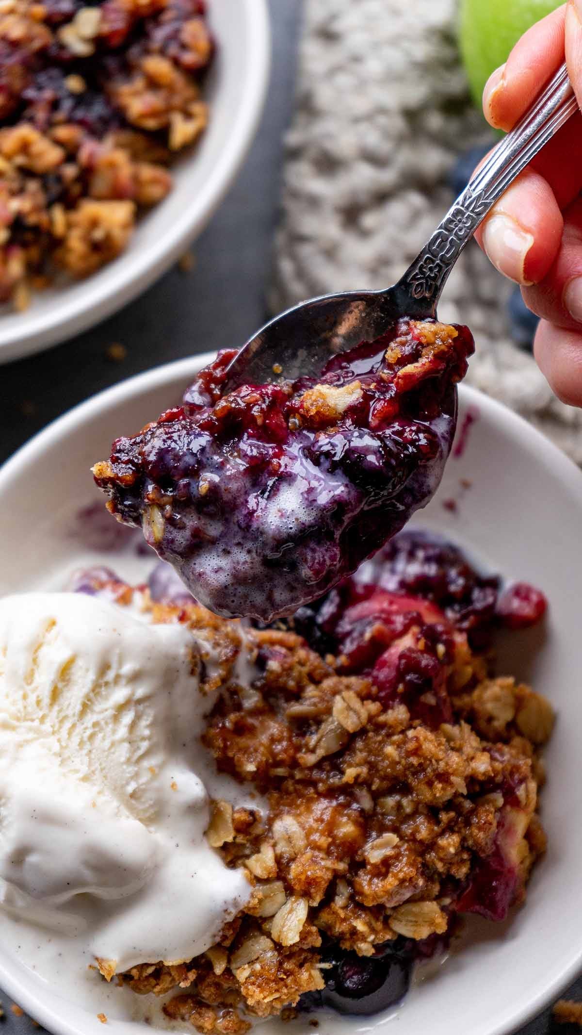 Apple Blueberry Crisp served in white bowls with vanilla bean ice cream