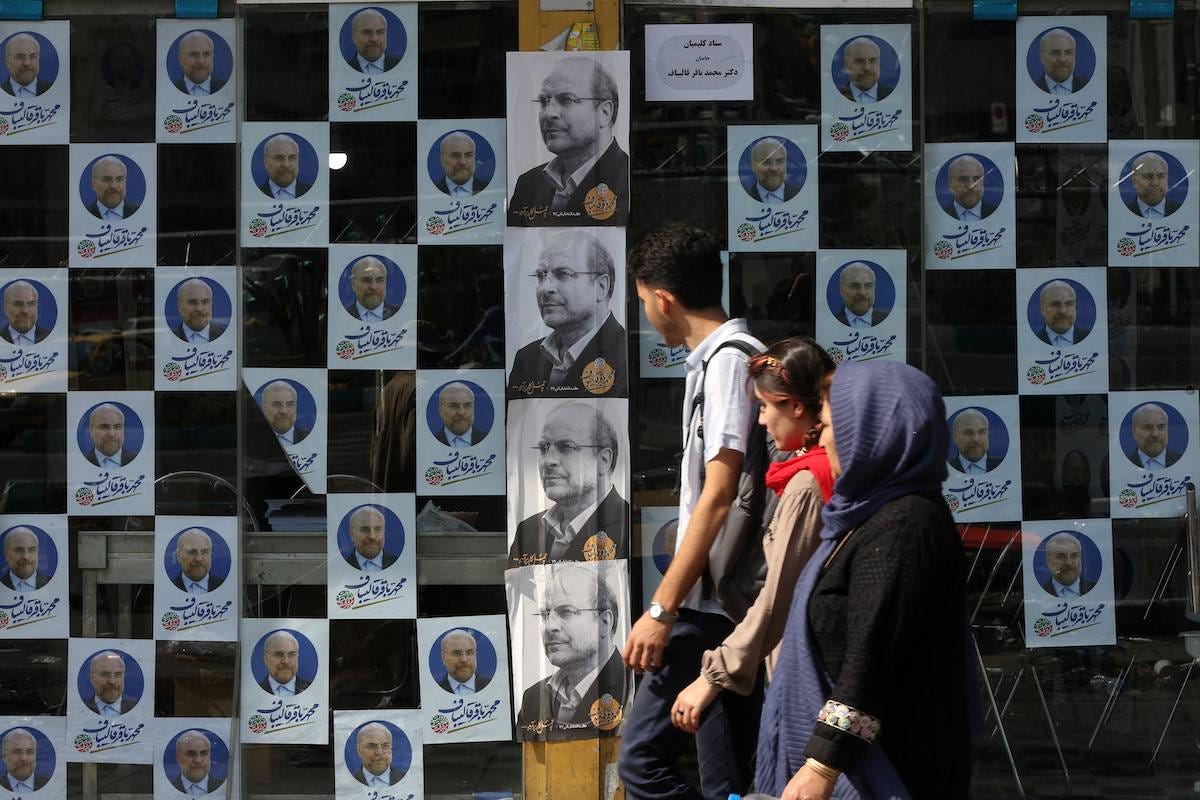 Citizens are seen walking in front of the candidate posters for the 14th presidential elections on the streets ahead of the early presidential election in Tehran, Iran on June 27, 2024. [Fatemeh Bahrami - Anadolu Agency]