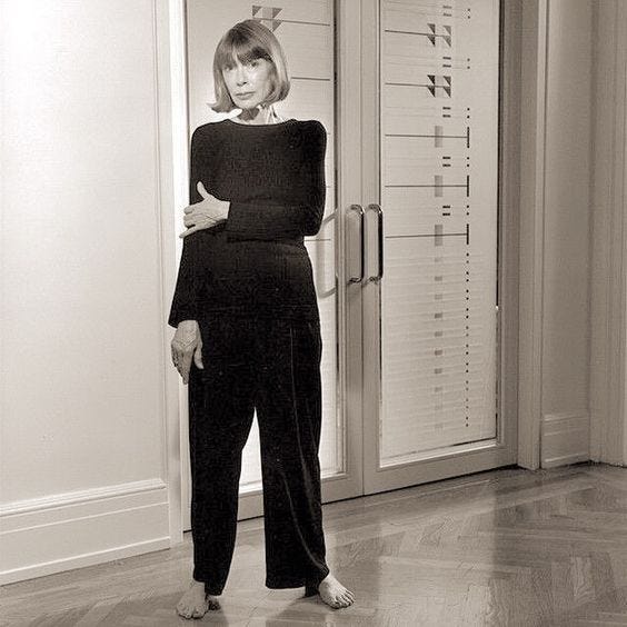 This may contain: a woman standing in front of a door with her hands on her hips and looking at the camera