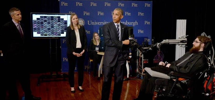Scientists Rob Gaunt, Jen Collinger and Sharlene Flesher watch President Barack Obama bump fists with the robot arm that Nathan Copeland controls with his brain Scientists Rob Gaunt, Jen Collinger and Sharlene Flesher watch President Barack Obama bump fists with the robot arm that Nathan Copeland controls with his brain