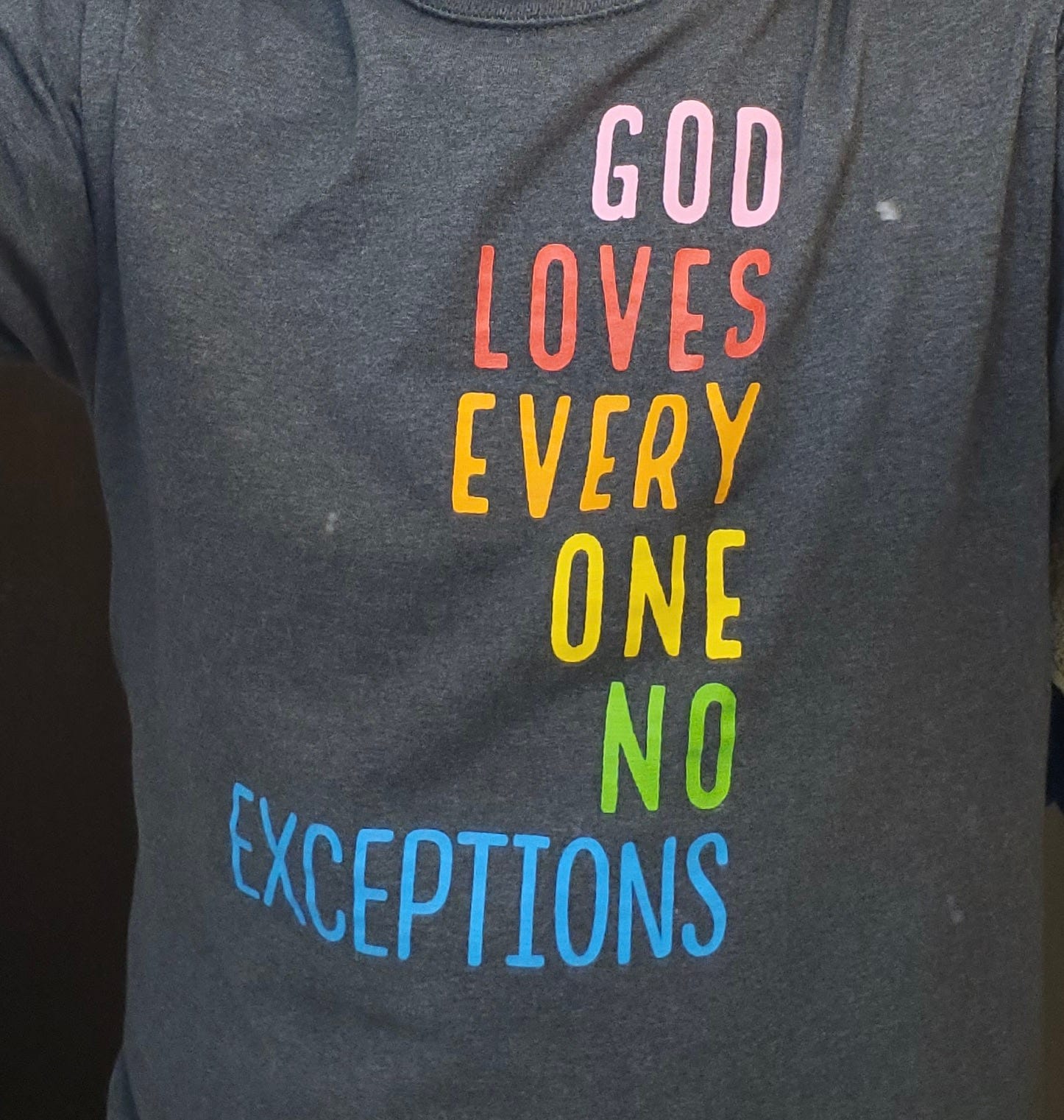 T shirt says "God loves everyone, no exceptions"