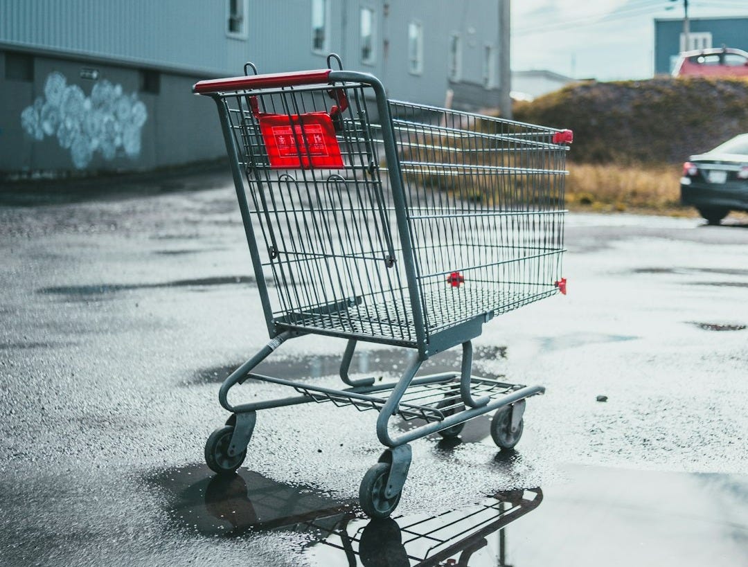 a shopping cart sitting in the middle of a parking lot