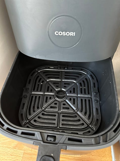 open ninja air fryer; open Cosori airfryer; two air fryer baskets side by side.