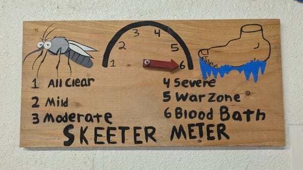 a handmade wooden sign with a gauge to "measure" how bad the mosquitoes are. It says Skeeter Meter" and has a scale that ranges from All Clear to Bloodbath a handmade wooden sign with a gauge to "measure" how bad the mosquitoes are. It says Skeeter Meter" and has a scale that ranges from All Clear to Bloodbath