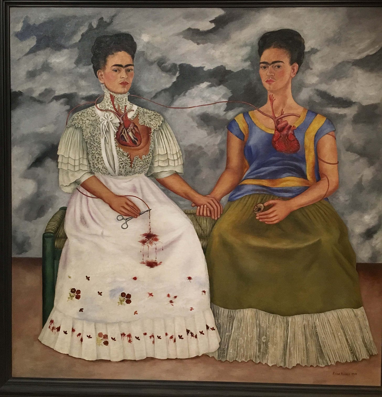 Two seated women holding hands, hearts exposed Two seated women holding hands, hearts exposed