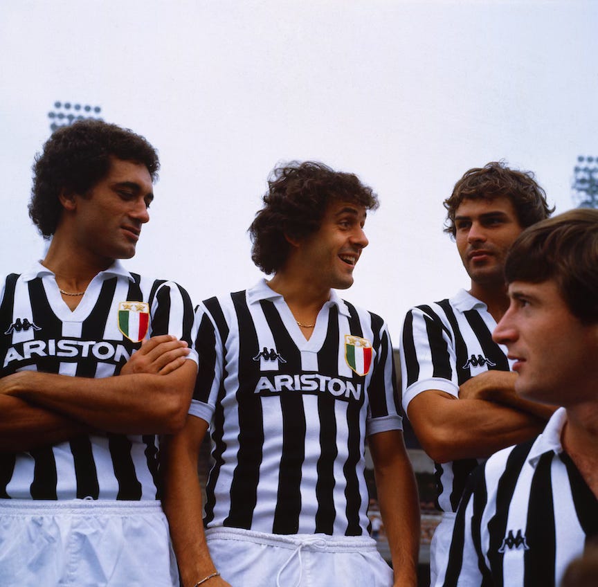 Michel Platini smiling with Juventus teammates in black and white Ariston jerseys during the 1980s.