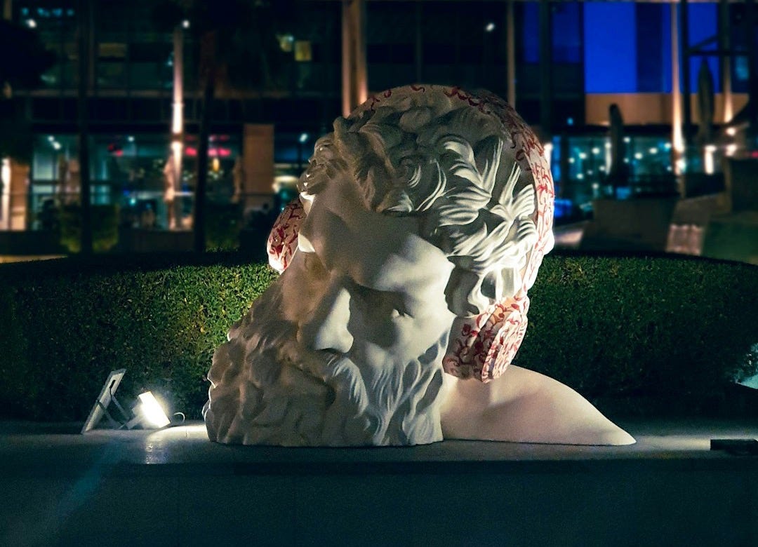 a statue of a woman in a park at night a statue of a woman in a park at night