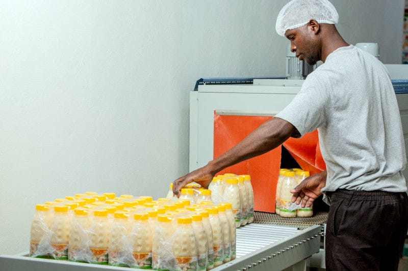 A Forest Africa Zambia employee handling packaged fruit juices. A Forest Africa Zambia employee handling packaged fruit juices.