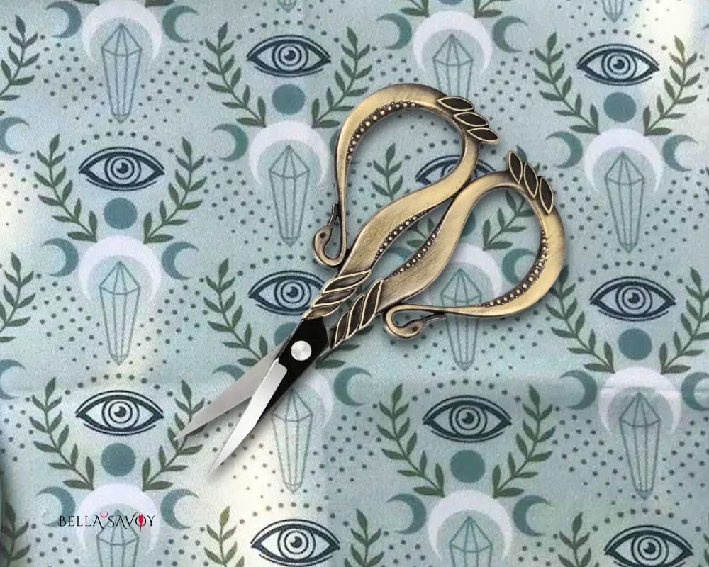 ornate embroidery scissors set on a mystical eye and crescent moon fabric