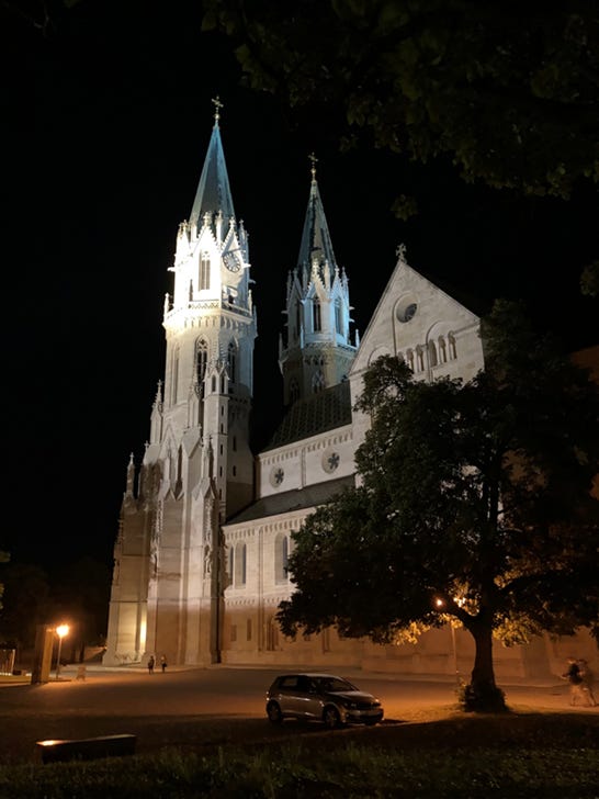 Title: UV-SOM-FD-01-Klosterneuburg-Abbey-at-Night.jpg - Description: Klosterneuburg Abbey illuminated at night, with its twin church towers rising against a black sky and trees framing the scene.