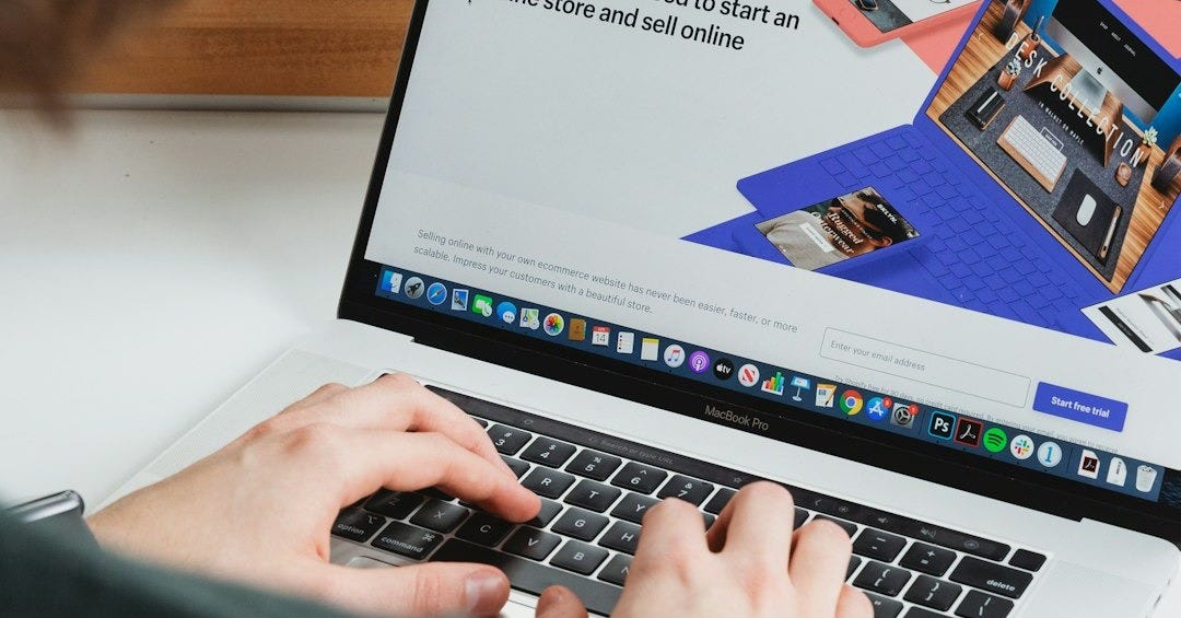 person using macbook pro on white table person using macbook pro on white table