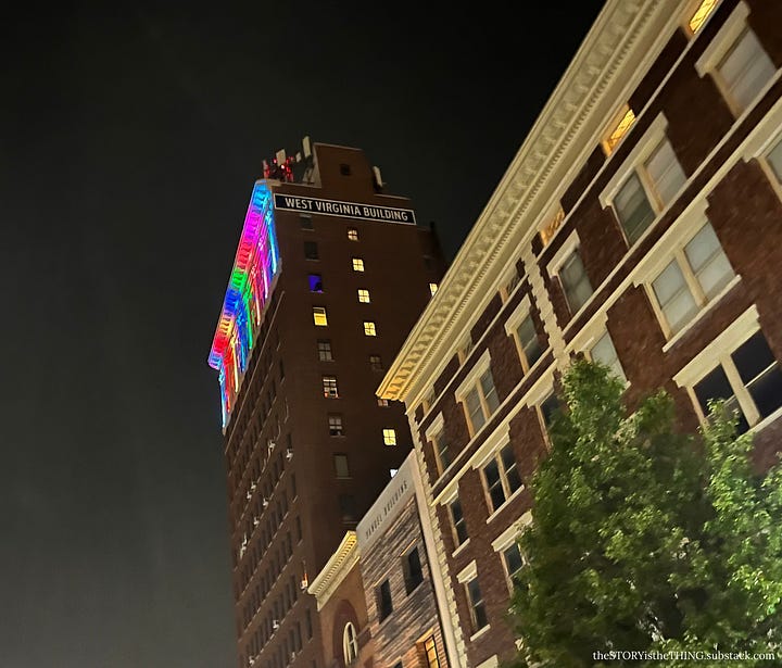 Four views of a downtown apartment building all light up in Pride Month colors in Huntington, West Virginia.