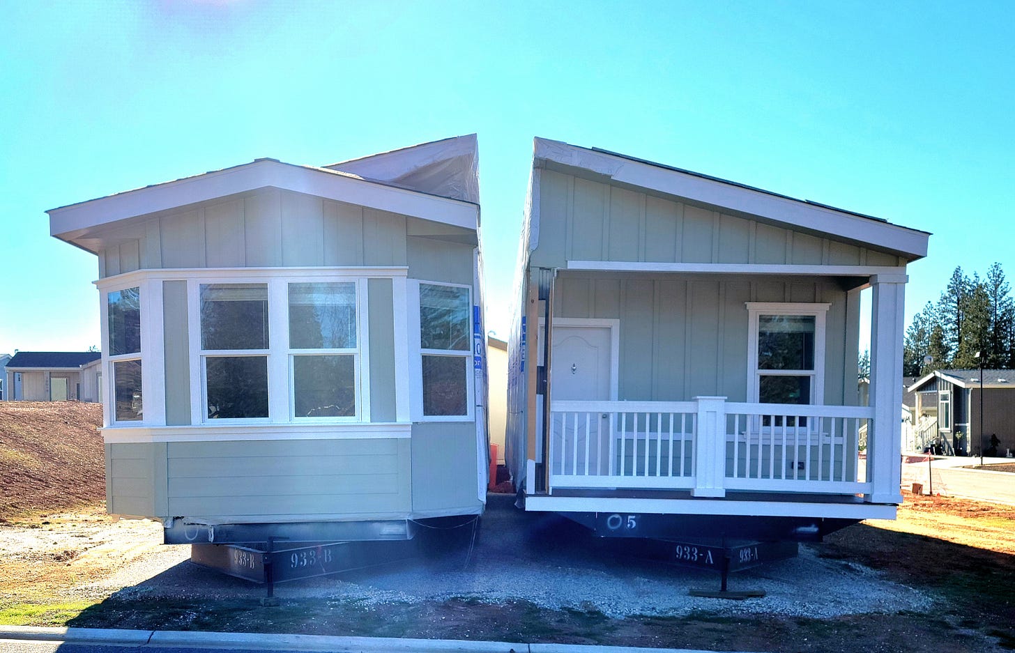 Front view of a manufactured home, split in two pieces, waiting to be put together on a foundation
