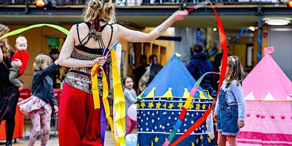 circus performer with kids dancing and play tents in the background circus performer with kids dancing and play tents in the background