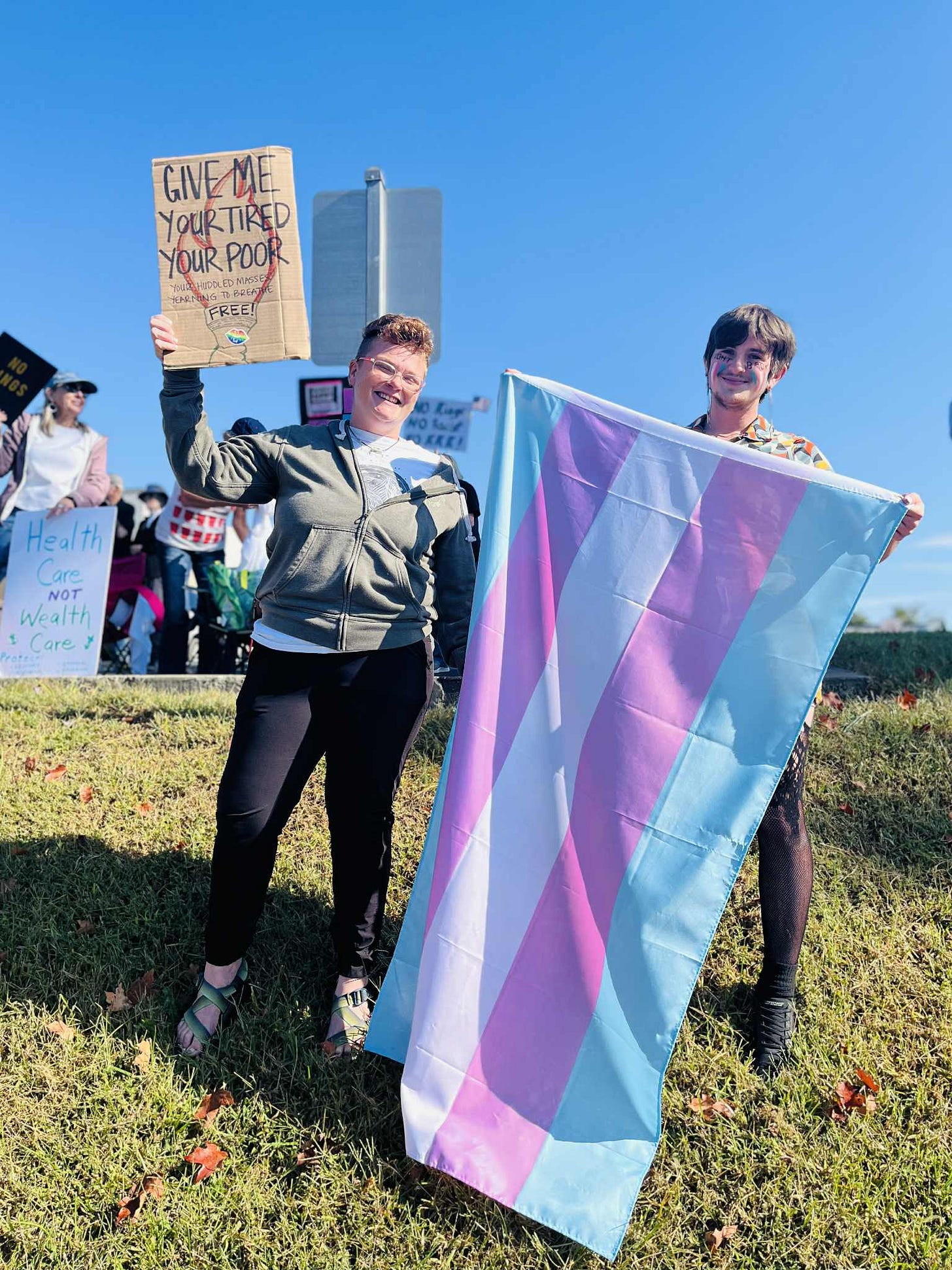 Jo Alberts and James Williams hold signs at the 'No Kings' protest