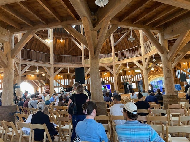 people sitting in chairs inside a wooden round barn