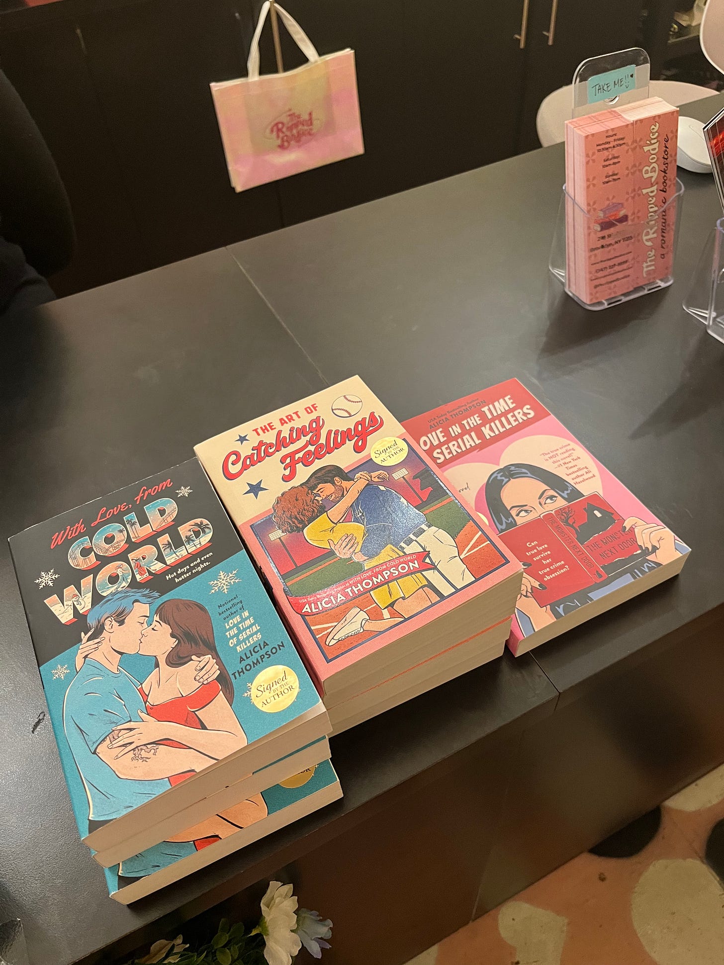 Photo of my books stacked on the counter of The Ripped Bodice