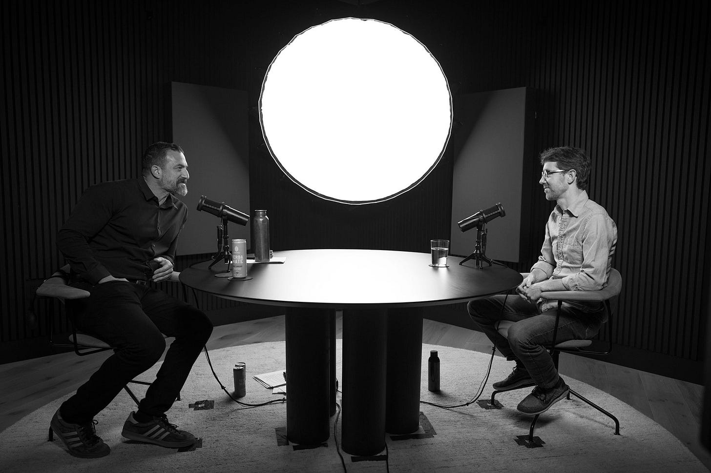 Black and white photo of Andrew Huberman and Martin Picard sitting at a table to record a podcast interview. Black and white photo of Andrew Huberman and Martin Picard sitting at a table to record a podcast interview.