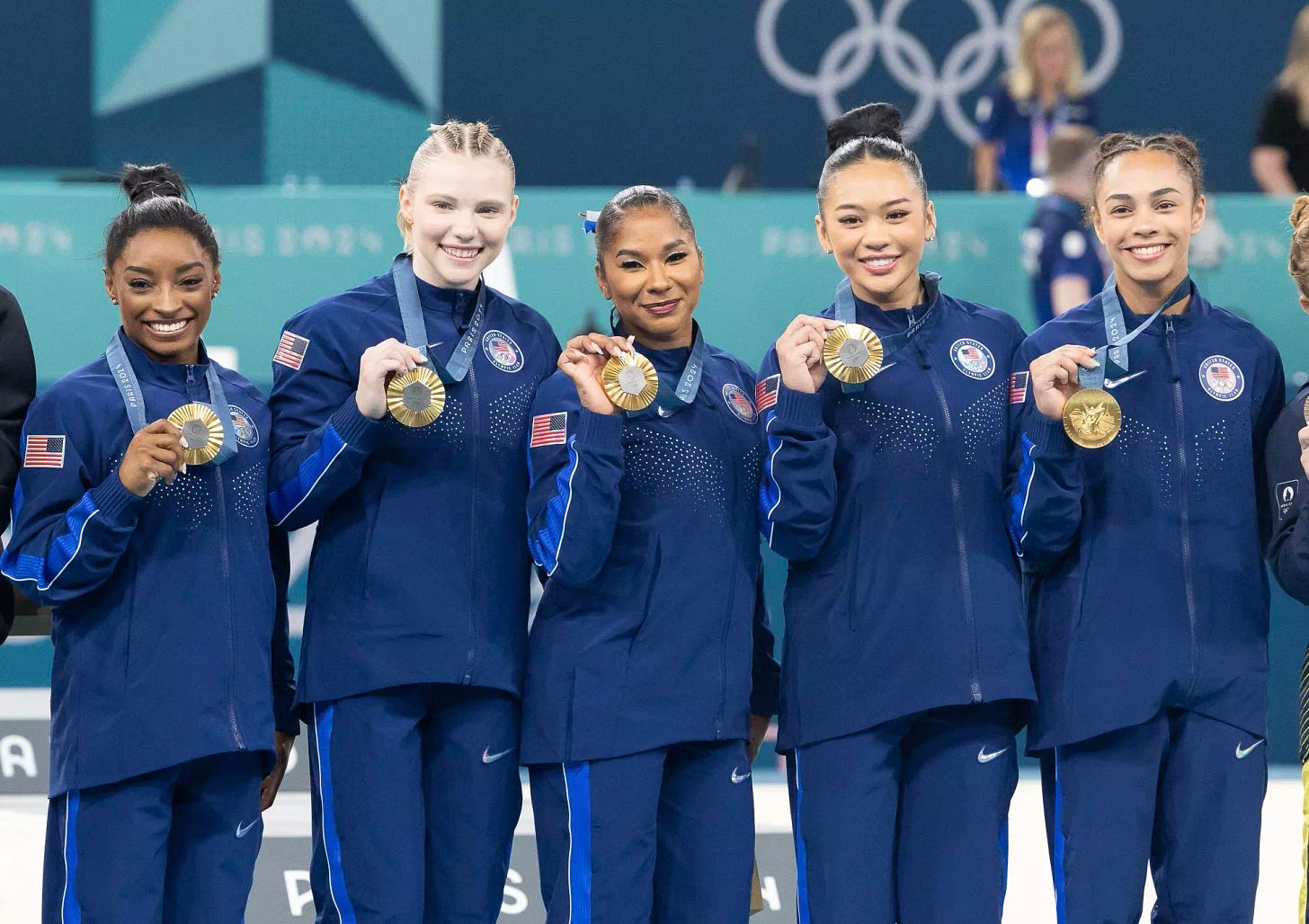 The U.S. women’s Olympic gymnastics team of Simone Biles, Jade Carey, Jordan Chiles, Sunisa Lee, and Hezly Rivera with their gold medals.