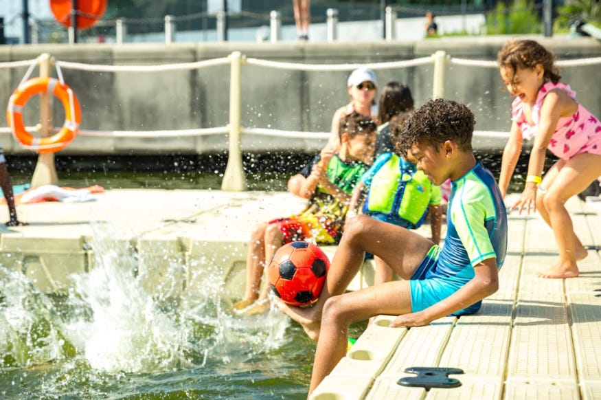 A boy sitting on the edge of a lido, splashing his legs in the water A boy sitting on the edge of a lido, splashing his legs in the water