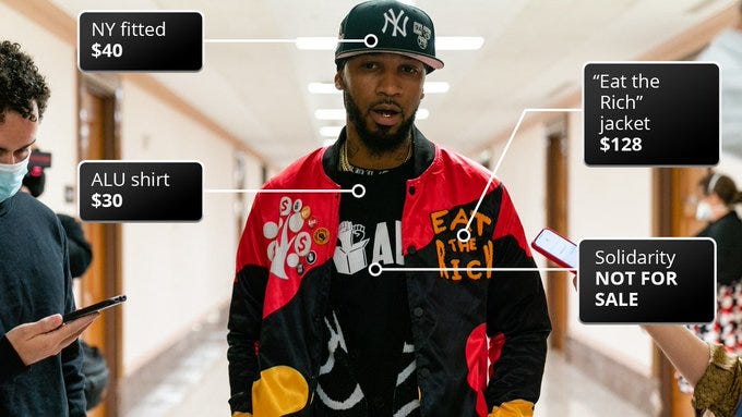 Chris Smalls wearing major drip with notes on each part of the outfit.

NY fitted: $40
ALU shirt: $30
"Eat the Rich" jacket: $128
Solidarity: NOT FOR SALE