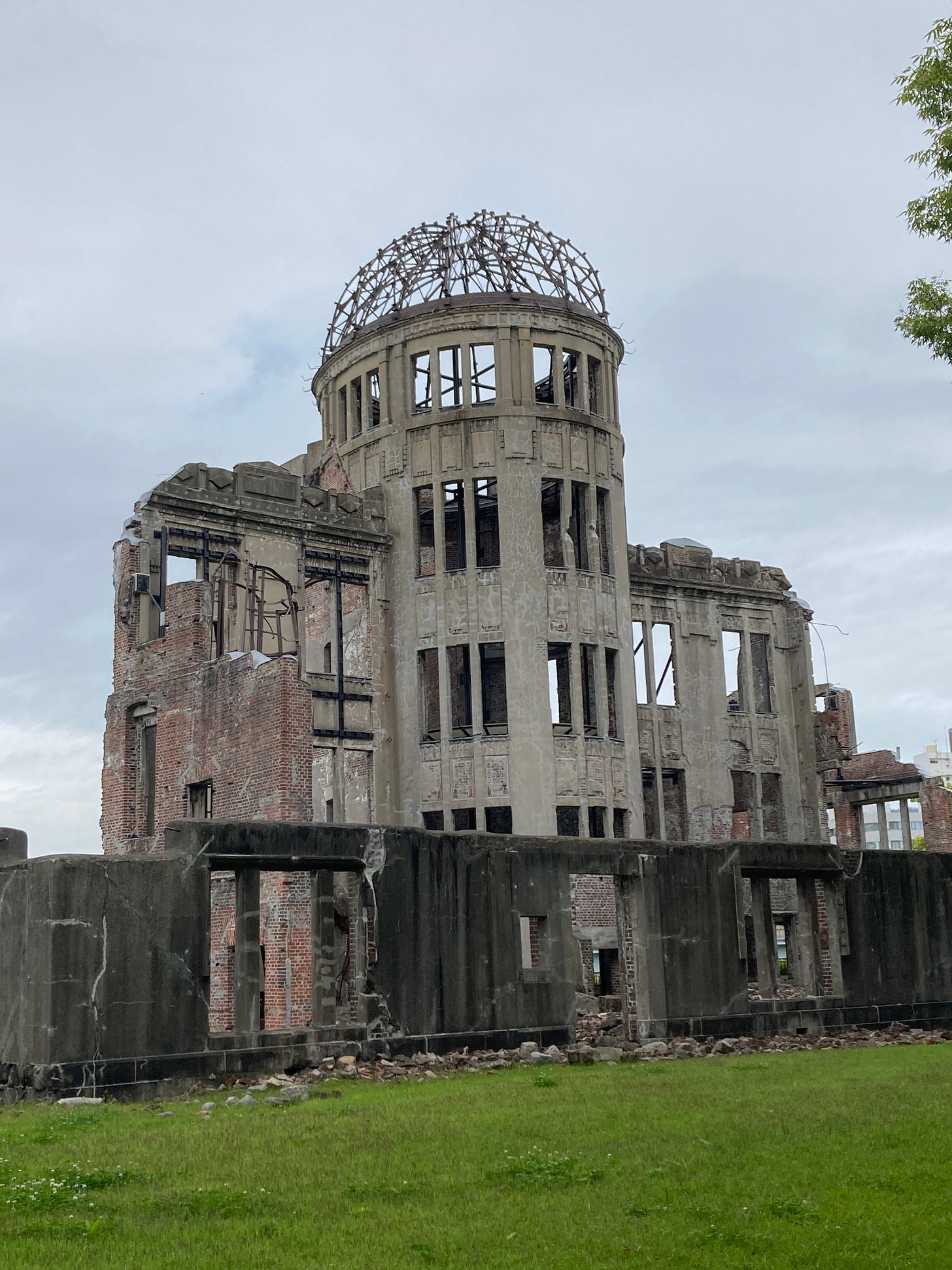Shell of a building with rubble at its base and only the metal beams of the dome on top.