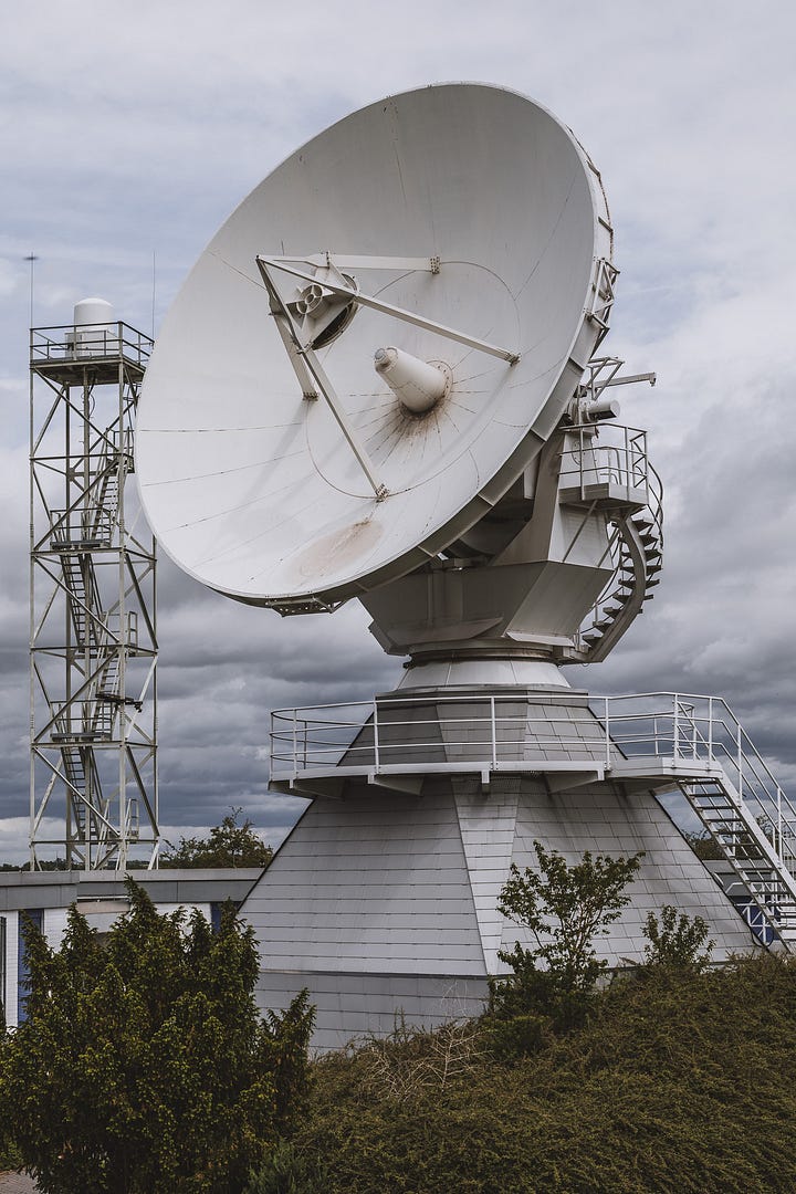 Eine große, motorbewegte Satellitenantenne und eine Rundstrahlantenne auf einem Stahlgerüst