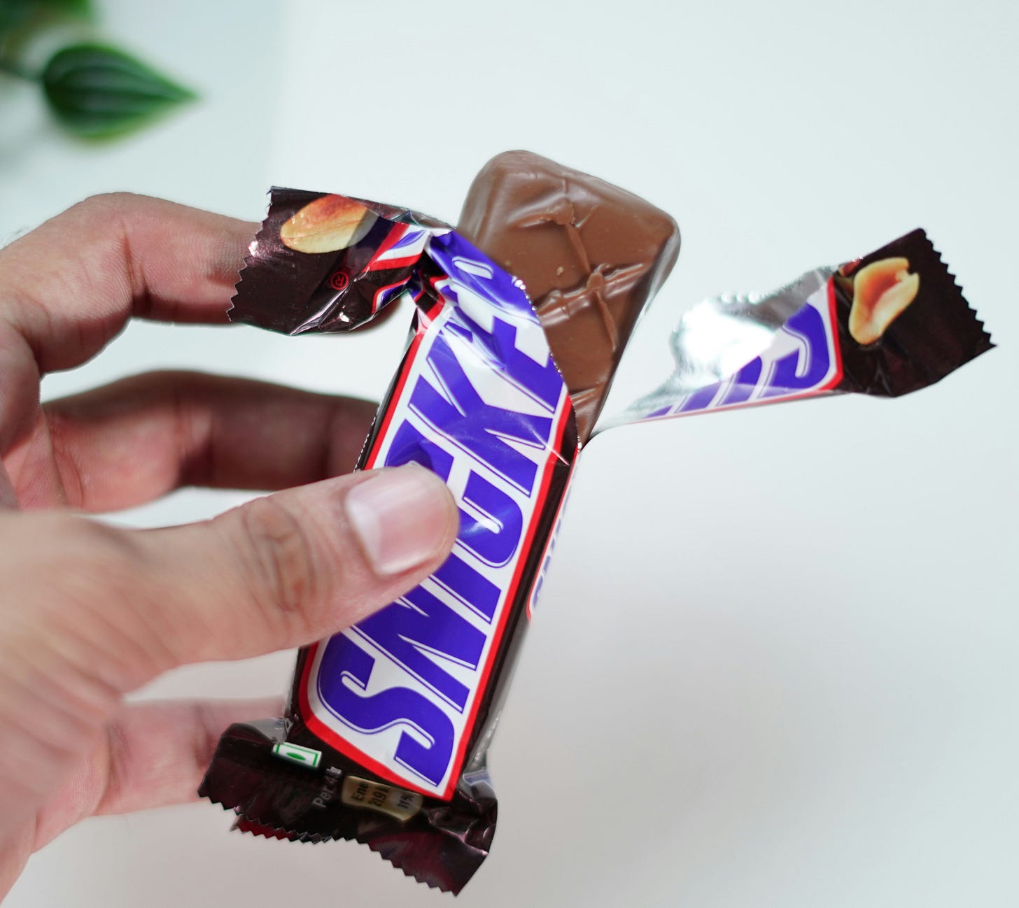 A Snickers candy bar, open on one end