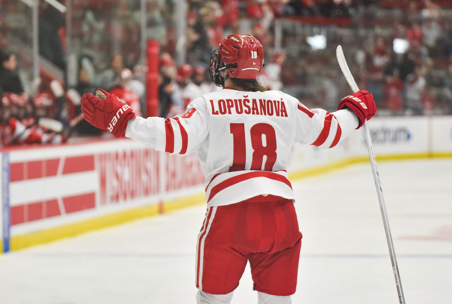 Nela Lopušanová lifts her arms wide to the air as she turns up ice