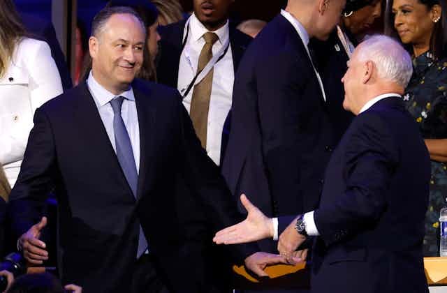 Two men in blue suits about to shake hands. Two men in blue suits about to shake hands.