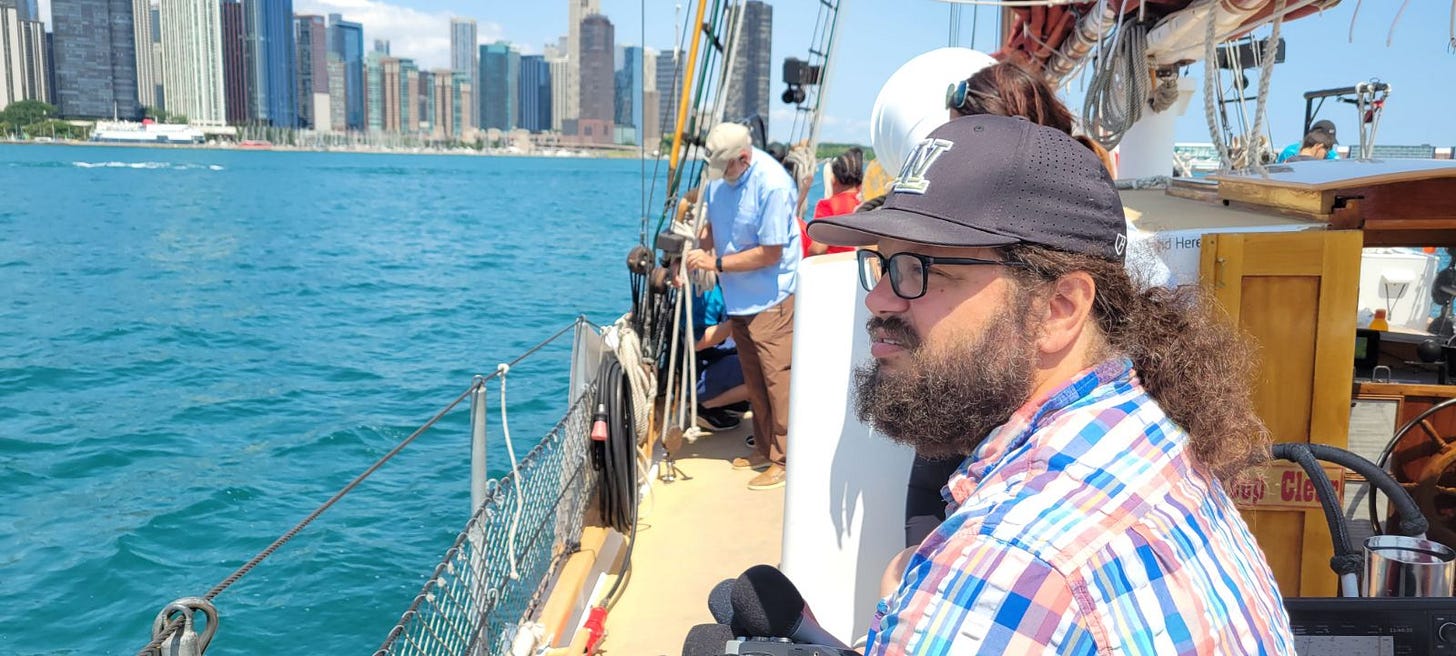 An image of Stuart Carlton sitting on a schooner overlooking the Chicago skyline