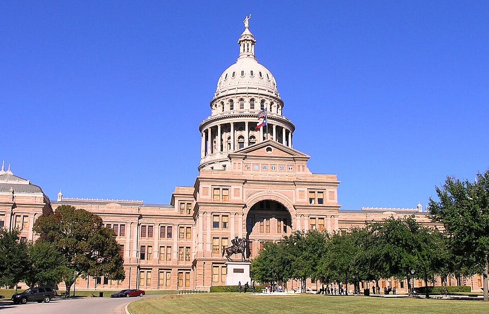 Texas Capitol with a horse and rider statue in the distant foreground Texas Capitol with a horse and rider statue in the distant foreground
