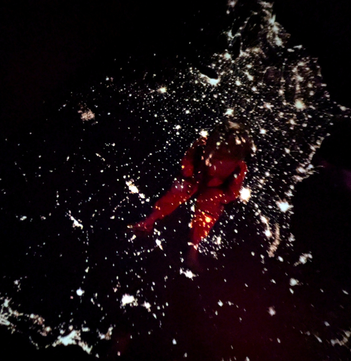 Boy in astronaut costume sitting under light projection of stars Boy in astronaut costume sitting under light projection of stars