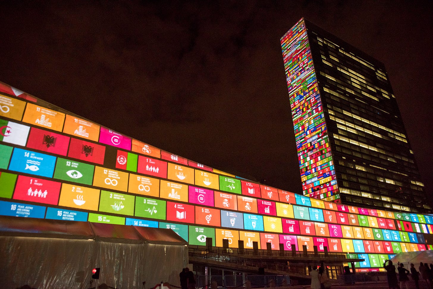 Brightly colored and lit up squares projected onto a building with a dark sky in the background. Brightly colored and lit up squares projected onto a building with a dark sky in the background.