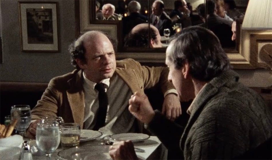 screenshot from My Dinner With Andre, with Wallace Shawn looking thoughtful as Andre Gregory speaks, one fist clenched to make a point screenshot from My Dinner With Andre, with Wallace Shawn looking thoughtful as Andre Gregory speaks, one fist clenched to make a point