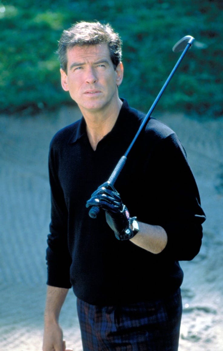 This may contain: a man holding a baseball bat on top of a dirt field next to a forest