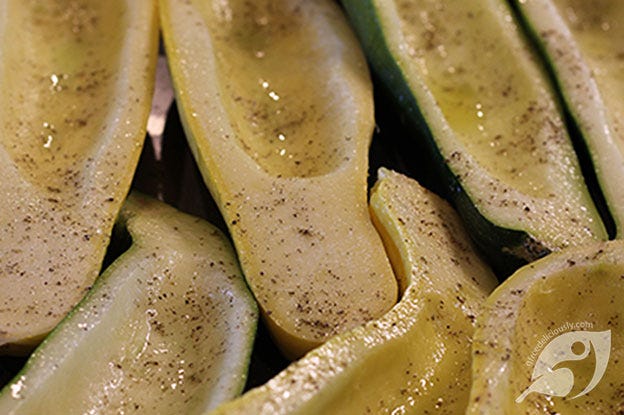 Zucchini and summer squash cut in half, seeds removed, and placed on a shallow pan then drizzled with roasted garlic grapeseed oil and sprinkled with salt and pepper. Zucchini and summer squash cut in half, seeds removed, and placed on a shallow pan then drizzled with roasted garlic grapeseed oil and sprinkled with salt and pepper.