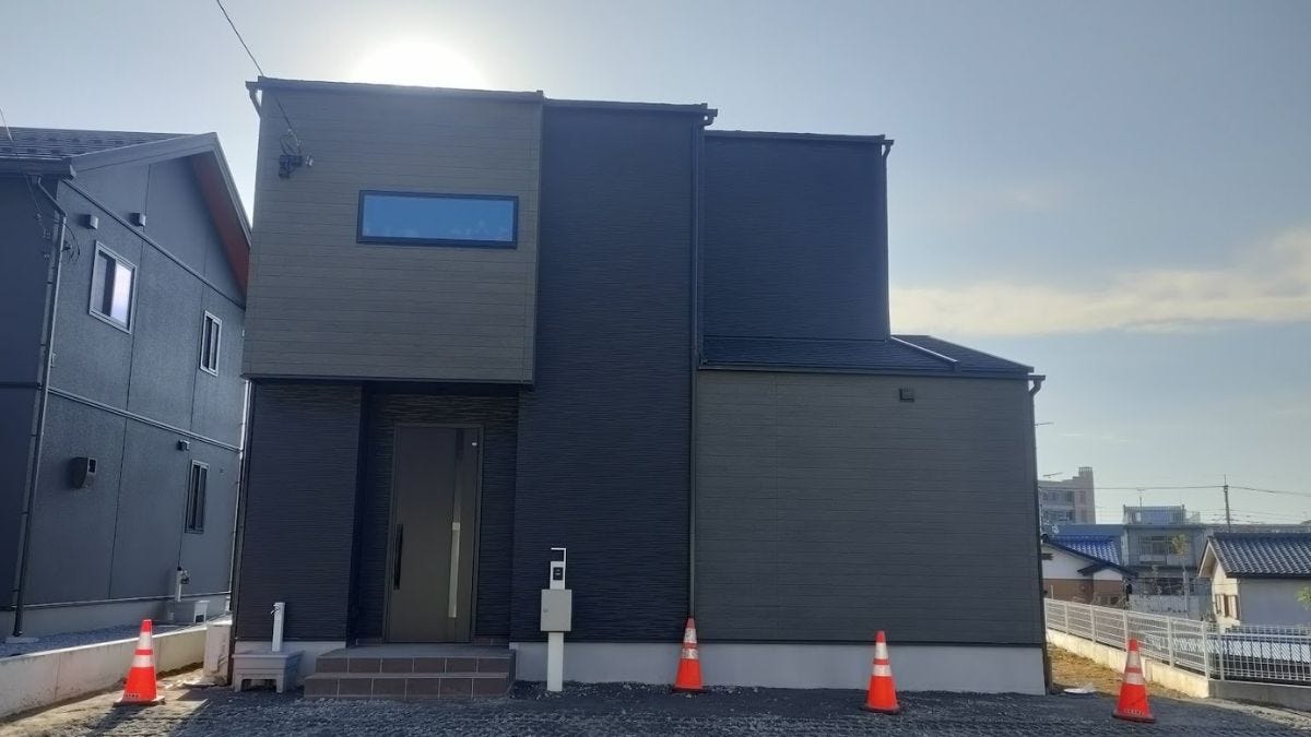 Modern Japanese house with minimal street-facing windows and clean blank front wall for privacy