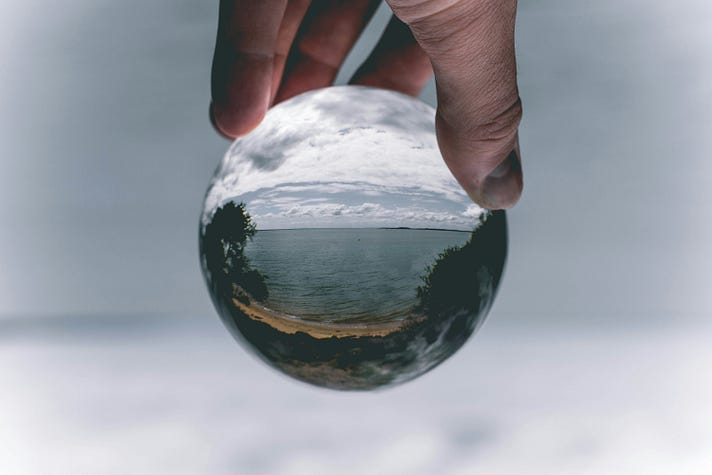 A globe being held in the fingers of a human hand. A globe being held in the fingers of a human hand.