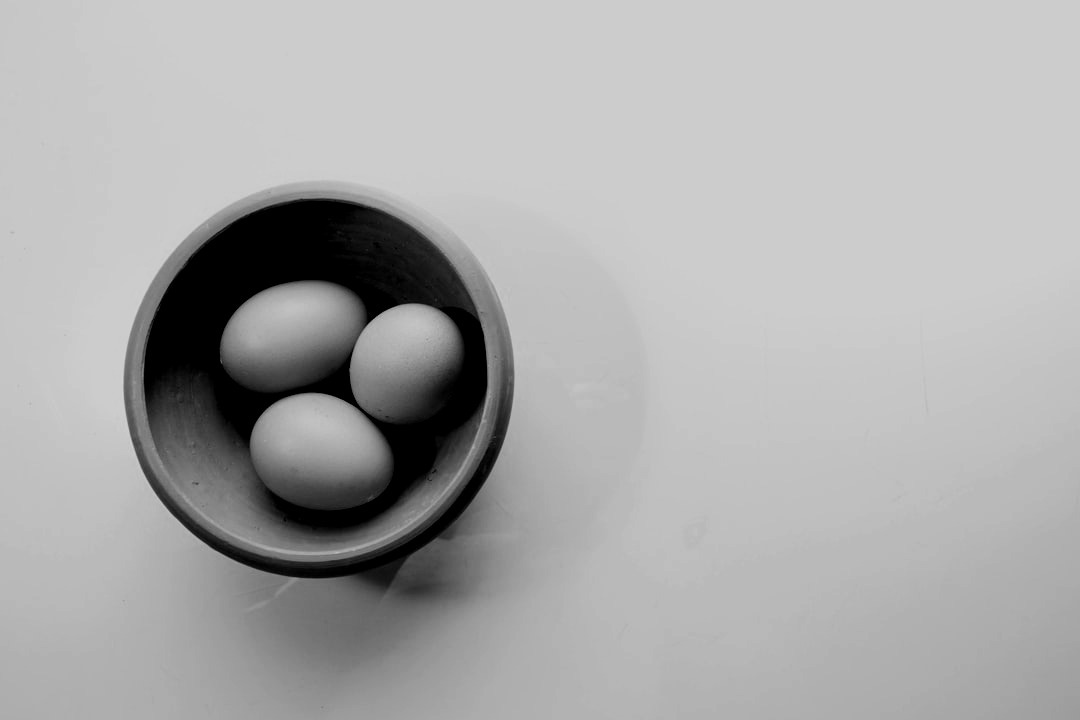 four eggs in a bowl on a white surface
